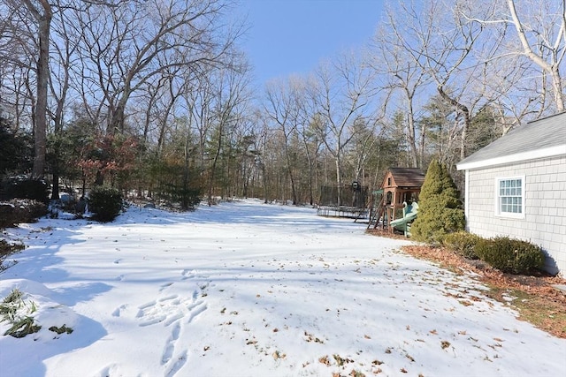 yard layered in snow featuring a playground