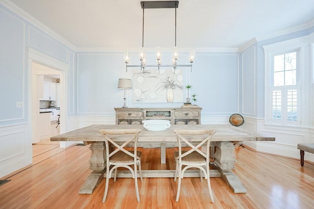 dining room featuring breakfast area, crown molding, and light hardwood / wood-style floors