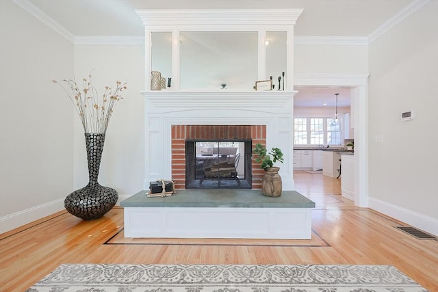 interior details with hardwood / wood-style floors, crown molding, and a brick fireplace