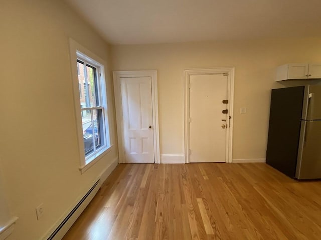 interior space with light hardwood / wood-style floors and a baseboard heating unit