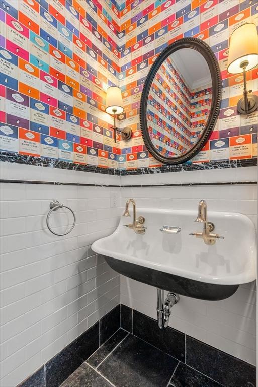 bathroom with sink and tile walls