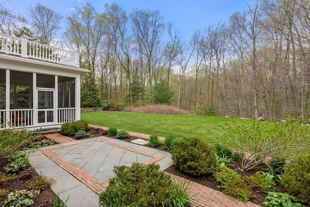 view of yard with a sunroom, a patio, and a balcony