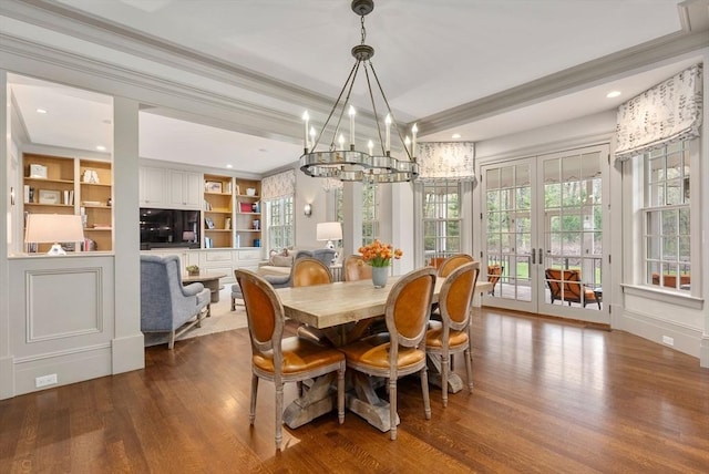 dining space with french doors, crown molding, hardwood / wood-style floors, and built in features