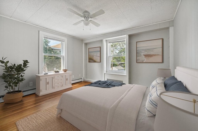 993 Shirley St, Winthrop, MA 02152 - bedroom featuring wood finished floors, multiple windows, baseboard heating, and ceiling fan