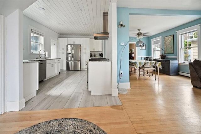 993 Shirley St, Winthrop, MA 02152 - kitchen with appliances with stainless steel finishes, wall chimney exhaust hood, white cabinetry, light wood finished floors, and a ceiling fan