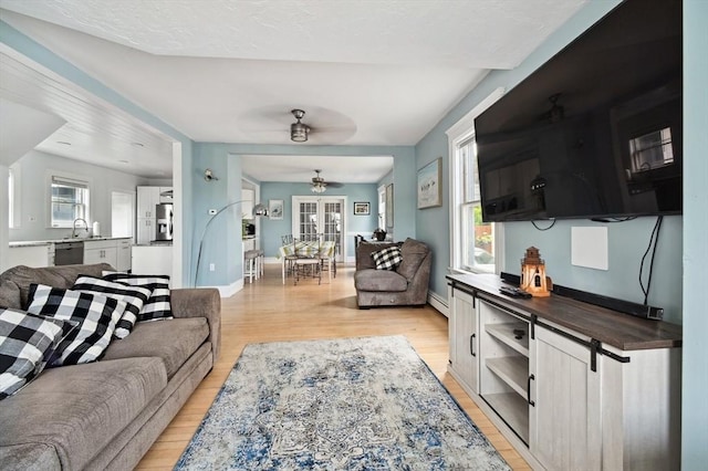 993 Shirley St, Winthrop, MA 02152 - living area featuring light wood-style floors, plenty of natural light, ceiling fan, and a baseboard heating unit