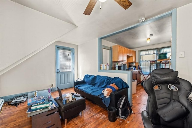 living room with ceiling fan, hardwood / wood-style floors, and vaulted ceiling