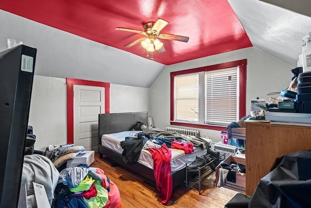 bedroom with ceiling fan, wood-type flooring, and lofted ceiling