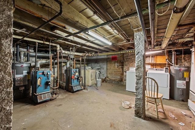 basement featuring washer and dryer, gas water heater, and electric water heater