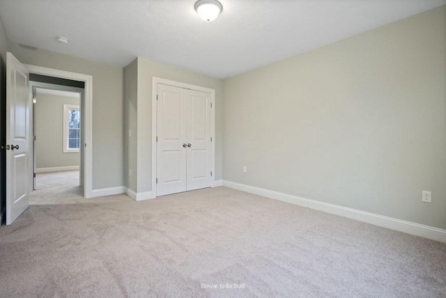 unfurnished bedroom featuring a closet and light carpet