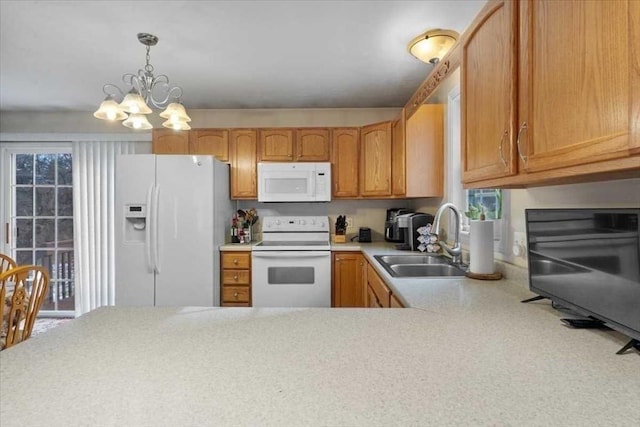 kitchen featuring sink, white appliances, decorative light fixtures, and a chandelier