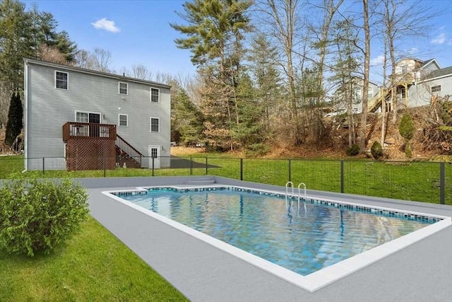 view of swimming pool featuring a yard and a deck