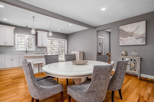 dining area featuring recessed lighting, light wood-style flooring, beam ceiling, and baseboards
