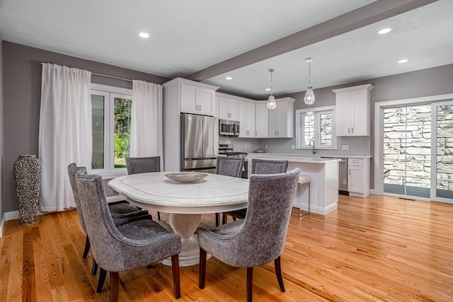 dining space with light wood-style floors, recessed lighting, and baseboards