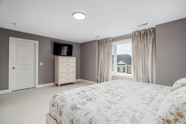 bedroom featuring light carpet and baseboards