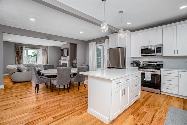 kitchen featuring stainless steel appliances, open floor plan, light wood-style floors, light countertops, and recessed lighting