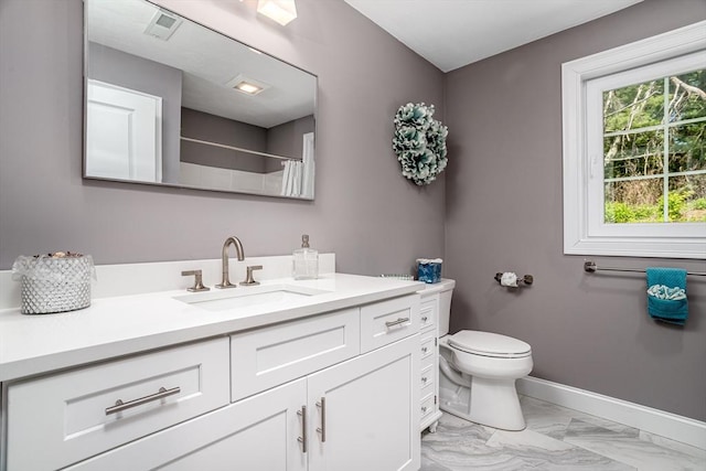 bathroom with toilet, vanity, a shower with curtain, marble look tiles, and baseboards