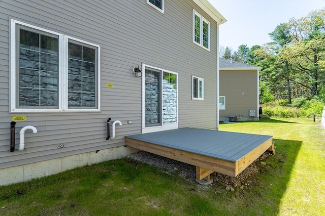 rear view of property with a wooden deck and a yard