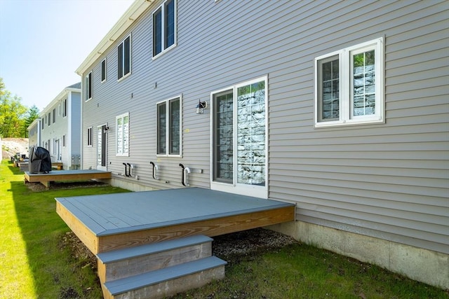rear view of property featuring a wooden deck and a yard