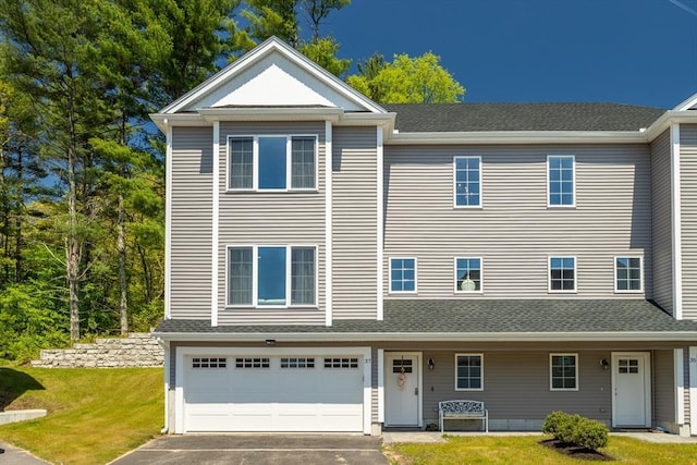 view of front of property featuring a garage, asphalt driveway, and a front yard