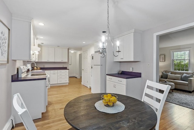 dining area featuring light wood finished floors, baseboard heating, recessed lighting, and baseboards