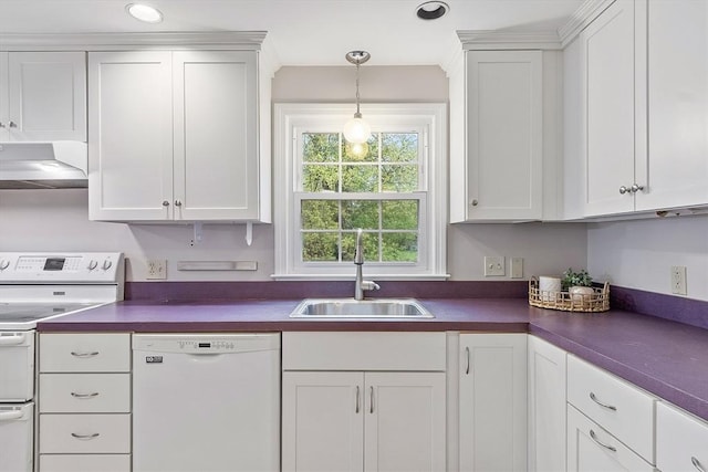 kitchen with white appliances, wall chimney exhaust hood, dark countertops, and a sink