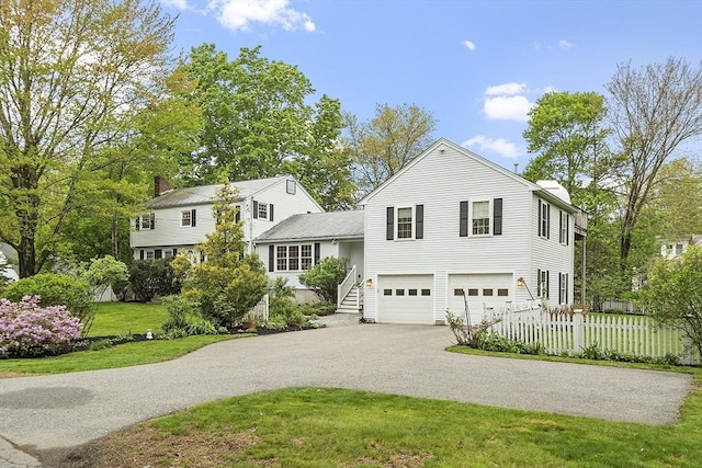 tri-level home featuring driveway, an attached garage, and stairs
