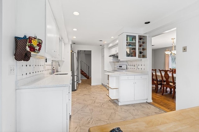 47 Churchill St, Sudbury, MA 01776 - kitchen with freestanding refrigerator, white range with electric stovetop, under cabinet range hood, tasteful backsplash, and glass insert cabinets