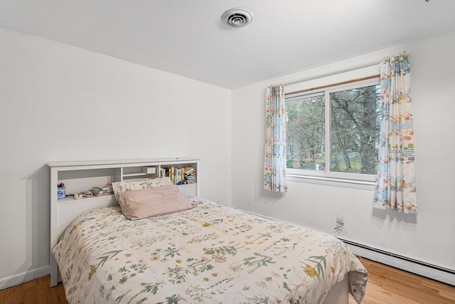 47 Churchill St, Sudbury, MA 01776 - bedroom with a baseboard radiator and wood finished floors