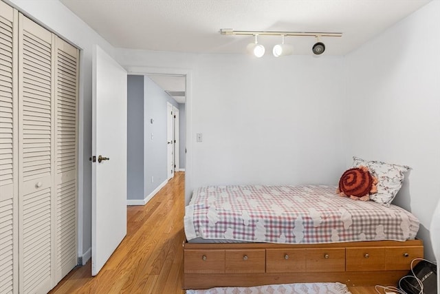 47 Churchill St, Sudbury, MA 01776 - bedroom featuring rail lighting, light wood-style flooring, and a closet