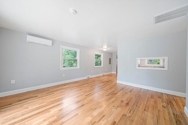 13 Hickory Rd, Halifax, MA 02338 - unfurnished room featuring a wall unit AC, light wood finished floors, and a smoke detector