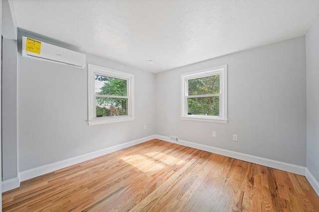 13 Hickory Rd, Halifax, MA 02338 - spare room featuring an AC wall unit, plenty of natural light, and light wood-style floors