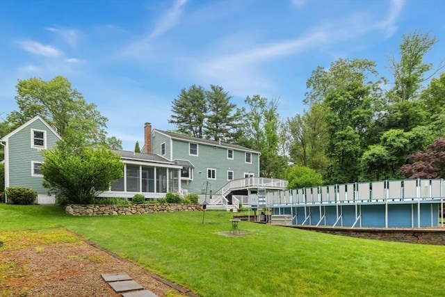 35 Faulkner Hill Rd, Acton, MA 01720 - back of house featuring a sunroom, an outdoor pool, a chimney, a yard, and a deck