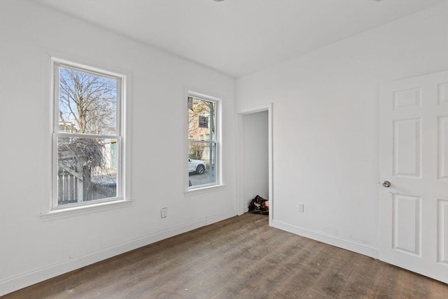 empty room featuring baseboards and wood finished floors