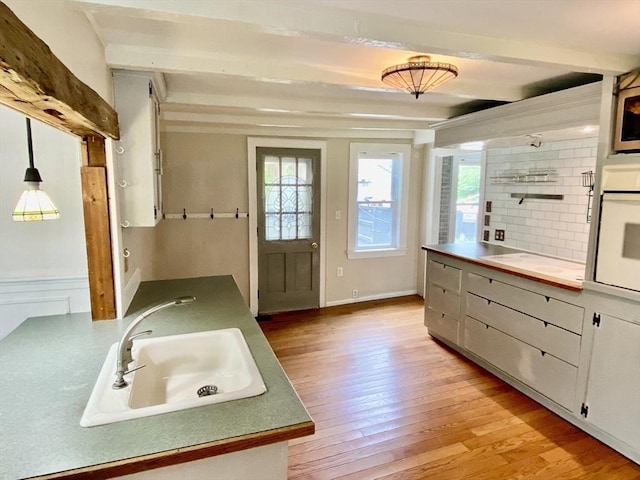 387 W Washington St, Hanson, MA 02341 - kitchen featuring white oven, light wood-type flooring, and beamed ceiling