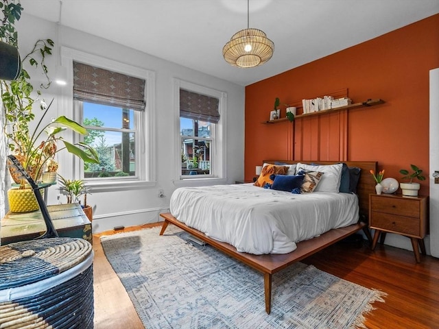 bedroom with wood finished floors and baseboards