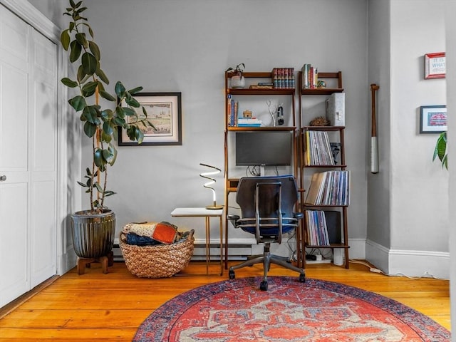 office with wood-type flooring, baseboards, and baseboard heating