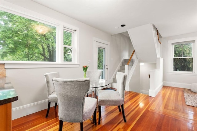 dining room with wood finished floors, stairway, and baseboards