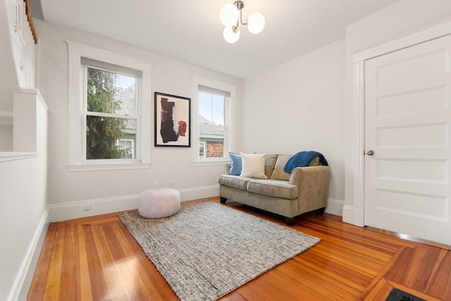 sitting room with light wood-style floors, baseboards, and a chandelier