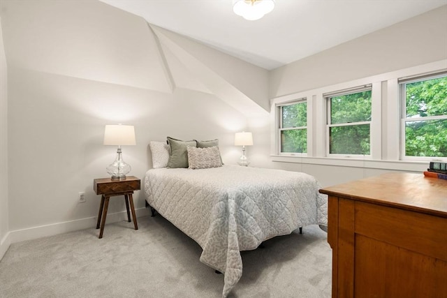 bedroom with multiple windows, baseboards, and light colored carpet