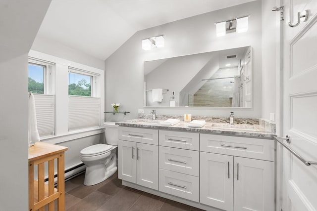 bathroom with a baseboard heating unit, vaulted ceiling, toilet, double vanity, and a walk in shower