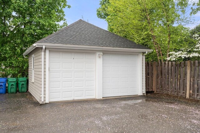 detached garage featuring fence