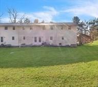 rear view of property featuring a lawn
