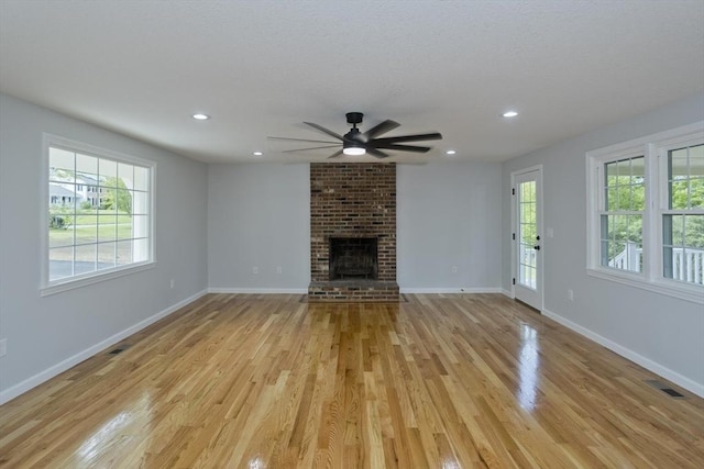 unfurnished living room featuring ceiling fan, light wood-style flooring, a fireplace, baseboards, and recessed lighting