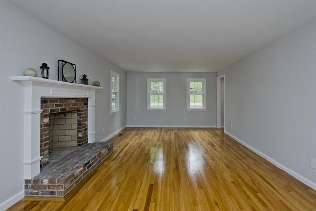 unfurnished living room featuring wood finished floors and baseboards