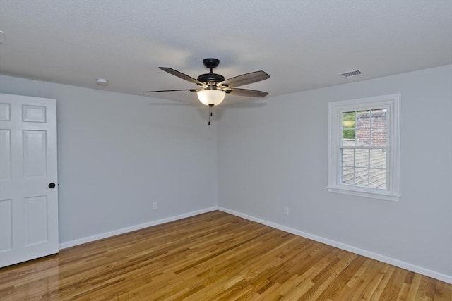 unfurnished room with light wood finished floors, baseboards, ceiling fan, and a smoke detector