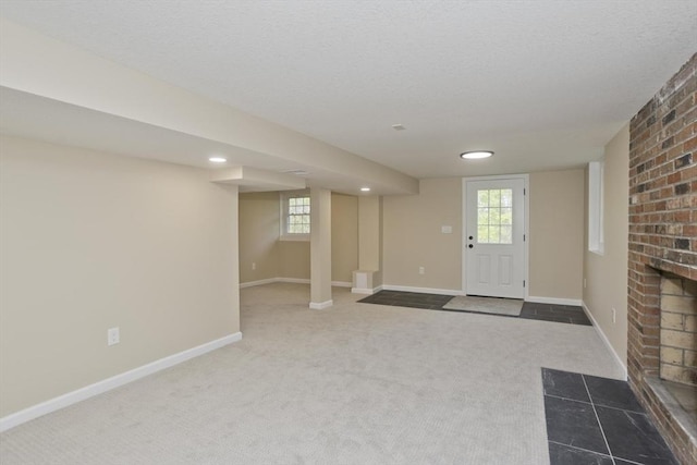 carpeted entrance foyer with baseboards, plenty of natural light, a fireplace, a textured ceiling, and recessed lighting