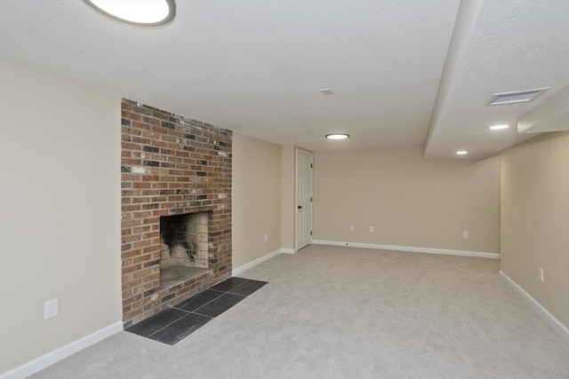 unfurnished living room with carpet floors, a brick fireplace, baseboards, recessed lighting, and a textured ceiling