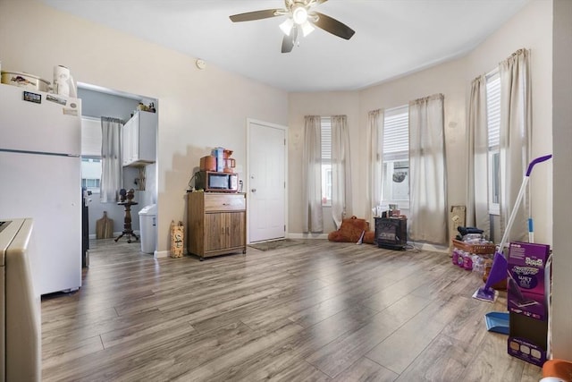 miscellaneous room featuring baseboards, a ceiling fan, and wood finished floors