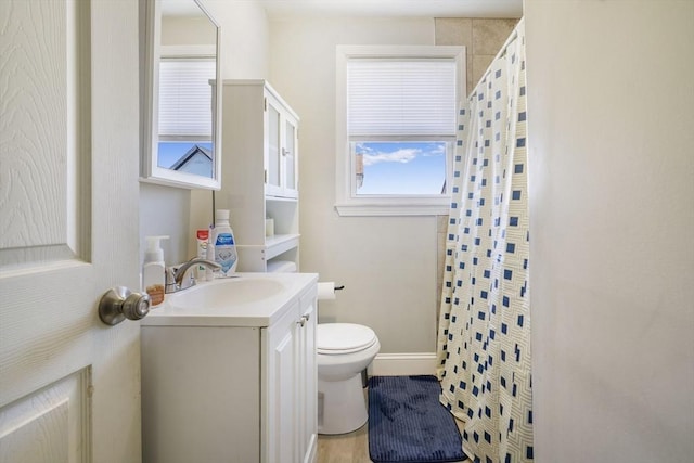 bathroom featuring toilet, baseboards, a shower with shower curtain, and vanity